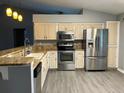 Bright kitchen with stainless steel appliances and granite countertops and gray flooring at 6419 Borg St, Leesburg, FL 34748