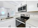 Modern kitchen with stainless steel appliances, quartz countertops, and white cabinetry at 6508 Coral Cove Dr, Orlando, FL 32818