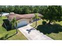 Aerial shot of single-story home with mature trees, long driveway and large, fenced yard at 717 Wedge Ln, Kissimmee, FL 34759