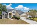 Charming two-story home featuring a two-car garage, a meticulously landscaped front yard, and a walkway leading to the arched entryway at 8603 Black Creek Blvd, Orlando, FL 32829