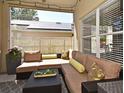 Relaxing outdoor patio with comfortable seating, stylish decor, and a view of the backyard fence and roof of adjacent property at 9573 Southern Garden Cir, Altamonte Springs, FL 32714