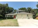 Home featuring a three-car garage and well-manicured front yard at 1101 N Division St, Oviedo, FL 32765
