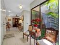 Sunlit entryway with decorative chairs, table, and atrium views from large window at 1139 Fairway Dr, Winter Park, FL 32792