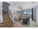 Inviting living room with wood floors, a ceiling fan, gray furniture, and sliding glass doors at 1236 S Beach Cir, Kissimmee, FL 34746