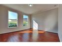 Bright bedroom featuring hardwood floors and two windows overlooking greenery at 130 Circle Hill Rd, Sanford, FL 32773