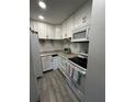 Efficient kitchen with white cabinets, granite countertops, and stainless steel appliances at 130 Jasmine Woods Ct # 6D, Deltona, FL 32725