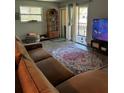 Comfortable living room with stylish rug and sliding glass doors to a balcony at 130 Jasmine Woods Ct # 6D, Deltona, FL 32725