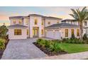 Beautiful new construction home featuring lush landscaping, a paver driveway, and a three-car garage at 16808 Bolsena Dr, Bella Collina, FL 34756