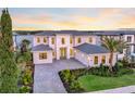 Stunning two-story home boasts water views, manicured landscaping, paver driveway, and a three-car garage at 16808 Bolsena Dr, Bella Collina, FL 34756
