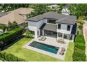 Aerial view of a modern home with a backyard oasis including a swimming pool, patio, and lush green lawn at 1700 Palm Ave, Winter Park, FL 32789
