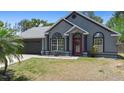 Charming single-story home featuring a red front door, a well-manicured lawn, and a two-car garage at 1848 Jimson Ave, Ocoee, FL 34761