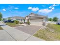 Charming single-story home with a brick-paved driveway, two-car garage, and manicured front lawn at 210 Hydra Way, Groveland, FL 34736