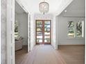 Elegant foyer with hardwood floors, a chandelier, and a wood-framed glass door at 2171 Forrest Rd, Winter Park, FL 32789