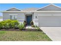A charming house with a well-maintained lawn, landscaping and a blue front door at 236 Aquamarine Ln, Kissimmee, FL 34758