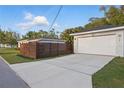 Long concrete driveway to a home with a detached garage and a wooden fence at 24 W King St, Orlando, FL 32804
