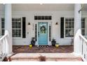 Inviting front porch with brick pavers, columns, blue door, and decorative plants at 2424 Antlia Dr, Orlando, FL 32828