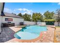 Beautiful backyard pool with a spa, basketball hoop, outdoor kitchen, and brick paver patio at 2424 Antlia Dr, Orlando, FL 32828