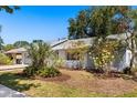A sunny shot of a well-maintained home exterior showing mature landscaping and neutral tones at 2623 Parsley Dr, Orlando, FL 32837