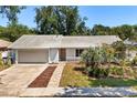 Charming single-story home features an attached garage, pathway and landscaping, enhancing its curb appeal at 2623 Parsley Dr, Orlando, FL 32837