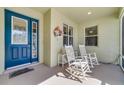 Inviting front porch with rocking chairs and decorative door with glass inserts. A relaxing spot to unwind at 26712 Augusta Springs Cir, Leesburg, FL 34748
