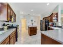 Large kitchen boasting stainless steel appliances, center island, tile flooring, and wood cabinets at 26712 Augusta Springs Cir, Leesburg, FL 34748