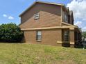 Side view of the two-story home, showing the well-maintained lawn and architectural details at 301 Blue Bayou Dr, Kissimmee, FL 34743