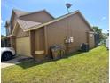 Side view of the two-story home, featuring a two-car garage and well-maintained lawn at 301 Blue Bayou Dr, Kissimmee, FL 34743