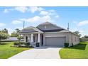 Single-story home features a well-maintained lawn, a two-car garage, and a light gray color scheme at 3753 Apopka Ridge Cir, Apopka, FL 32703