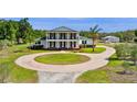 Beautiful view of the home, circular driveway, and detached garage surrounded by lush greenery and mature trees on the property at 4232 Spring Ln, Lakeland, FL 33811