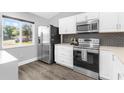 Modern kitchen featuring stainless steel appliances, white cabinets, and dark subway tile backsplash at 5809 Willow Bud Ct, Orlando, FL 32807