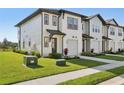 Townhouse featuring a well-maintained lawn and private walkway leading to the front door, enhancing curb appeal at 646 Longboat Dr, Davenport, FL 33896