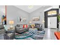 Cozy living room with comfortable seating, stylish decor, and a bright open entryway at 715 Troon Cir, Davenport, FL 33897