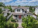 Charming two-story home showcasing a beautifully landscaped front yard and a striking red front door at 795 W Canton Ave, Winter Park, FL 32789
