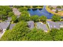 An aerial view of the property featuring a pool, waterfront views, and lush surrounding foliage at 8440 Woburn Ct, Windermere, FL 34786