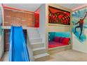 Themed bedroom with custom bunk beds, a built-in slide, and brick accent wall at 8814 Geneve Ct, Kissimmee, FL 34747