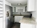 Modern kitchen with stainless steel refrigerator, granite countertops, and white cabinets at 912 Lake Destiny Rd # D, Altamonte Springs, FL 32714