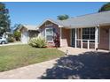 Charming single-story home with a well-manicured lawn and a brick-paved driveway at 9313 Pavillion Dr, Orlando, FL 32825