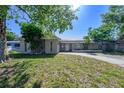 Street view of cozy single-story home with stone facade, solar panels on roof and a driveway at 941 Barbados Ave, Orlando, FL 32825