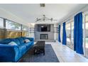Bright living room features a brick fireplace, modern ceiling fan, and sliding glass doors to a pool at 941 Barbados Ave, Orlando, FL 32825