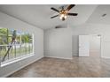Spacious living room with tiled floors, high ceilings, ceiling fan and natural light from the window at 996 Big Oaks Dr, Oviedo, FL 32765