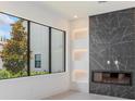Modern living area with large window, electric fireplace and elegant marble accent wall at 16825 Bolsena Dr, Montverde, FL 34756
