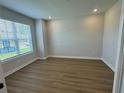 Bright bedroom features wood-look floors, neutral paint, and large window at 2592 Pine Preserve Ct, St Cloud, FL 34771