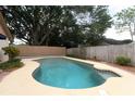 A lovely backyard swimming pool offers relaxation and recreation under the shade of mature trees at 406 Red Coat Ln, Orlando, FL 32825