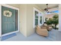 Inviting covered porch with comfortable seating and a stylish ceiling fan at 8778 Peachtree Park Ct, Windermere, FL 34786
