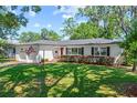 Charming home featuring a well-manicured lawn, inviting red door, and a two-car garage, exuding classic curb appeal at 919 Boardman St, Orlando, FL 32804