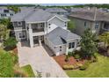 An aerial view shows the home with well-maintained lawn, paver driveway, and other homes in the neighborhood at 9421 Dugard Ct, Orlando, FL 32827