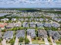 An aerial view of the neighborhood shows many homes, green lawns, and nearby lakes and trees at 9421 Dugard Ct, Orlando, FL 32827
