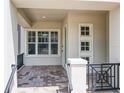 A covered front porch with tile flooring and black iron railings, offering a welcoming entrance at 9421 Dugard Ct, Orlando, FL 32827