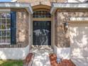 Close up of brick home exterior, featuring a black front door and well manicured landscaping at 10356 Stone Glen Dr, Orlando, FL 32825