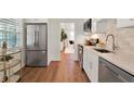 Modern kitchen featuring stainless steel appliances, white cabinets, and an open layout to the living room area at 108 S Glenwood Ave, Orlando, FL 32803